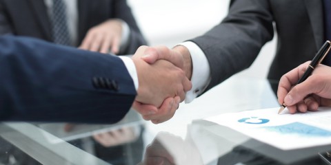 handshake business colleagues in office