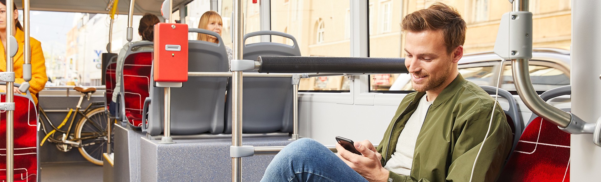Mann nutzt Smartphone im Bus.