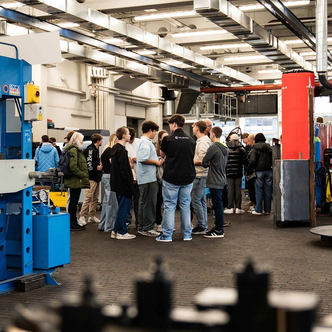 Junge Personen stehen im technischen Ausbildungszentrum der Salzburg AG.