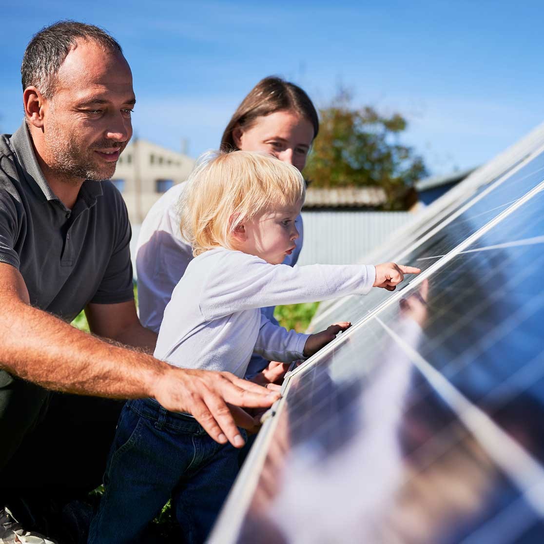 Eine Familie schaut sich Ihre PV-Anlage auf Ihrem Dach an