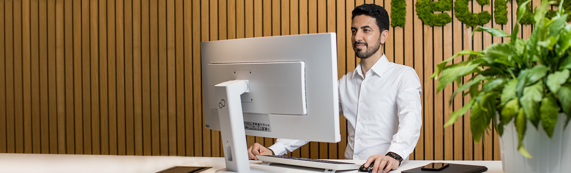 Mann arbeitet an modernem Computer.